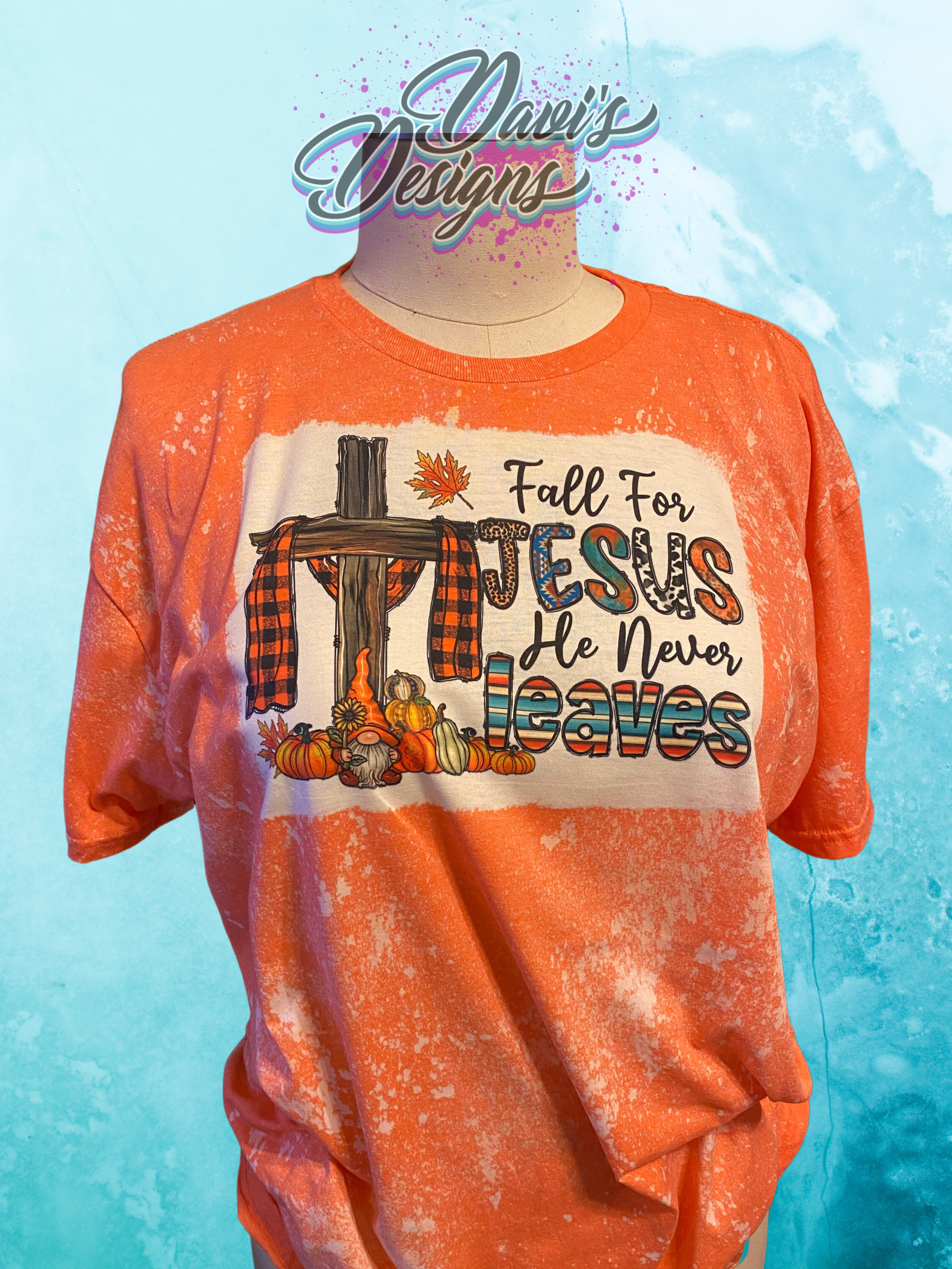 Heather Orange bleach patterned tee with a cross and pumpkins and the saying Fall for Jesus He Never Leaves.