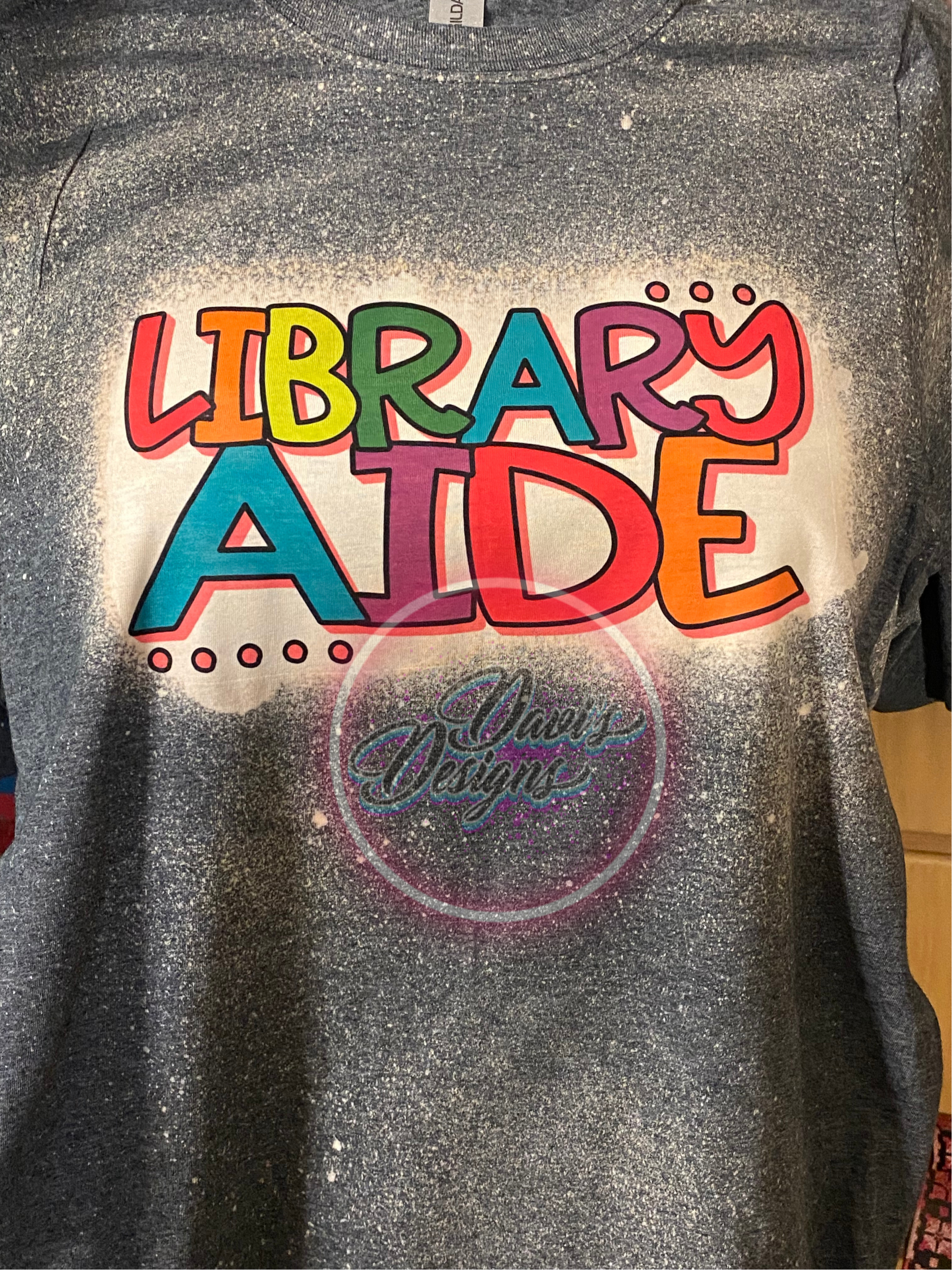 Dark Heather Bleached tee with Library Aide in orange, yellow, green, blue, purple, and red colors.