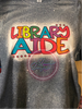 Dark Heather Bleached tee with Library Aide in orange, yellow, green, blue, purple, and red colors.